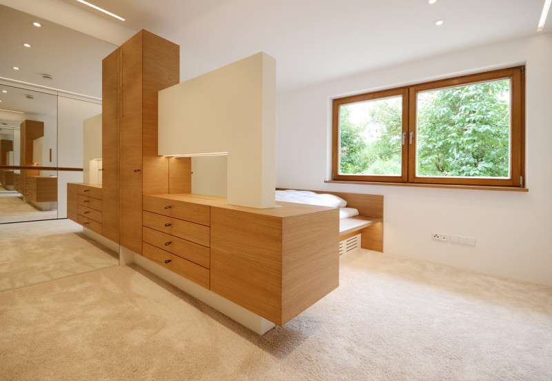 Modernes Schlafzimmer mit maßgefertigten Möbeln aus hellem Holz.