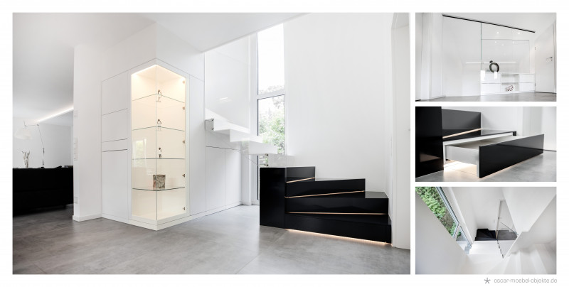 Minimalistischer Innenausbau inklusive schwarzer Holztreppe, beleuchteter Glasvitrine und beleuchteter Schubladen.